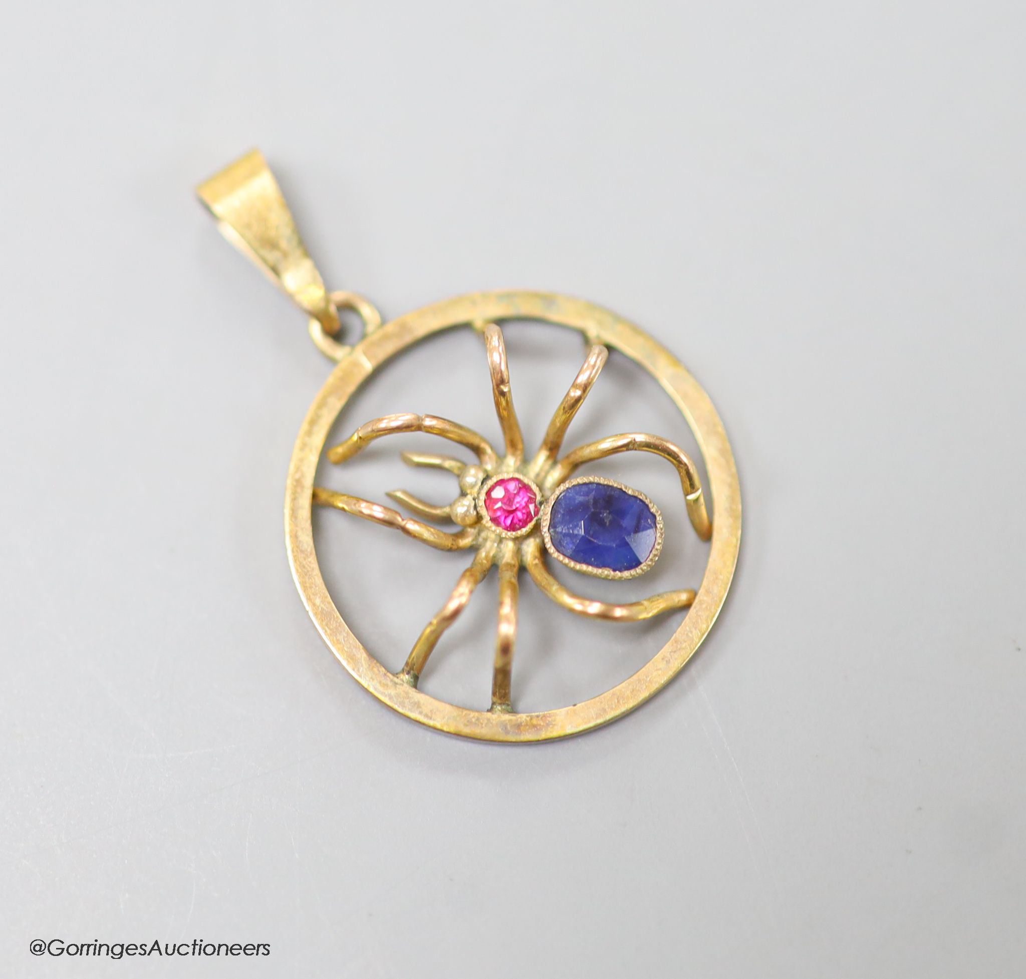 A 9ct, sapphire and ruby set circular spider pendant, 19mm, gross weight 1.9 grams.